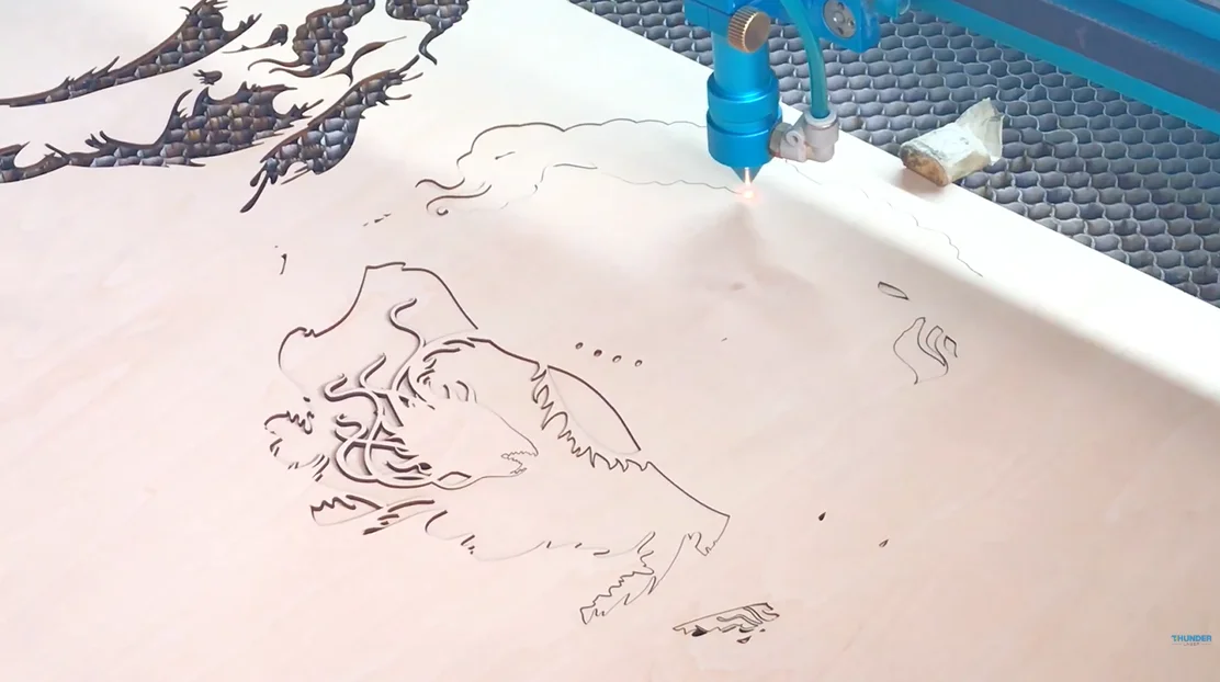 laser cutting multi-layered plywood dragon craft.webp
